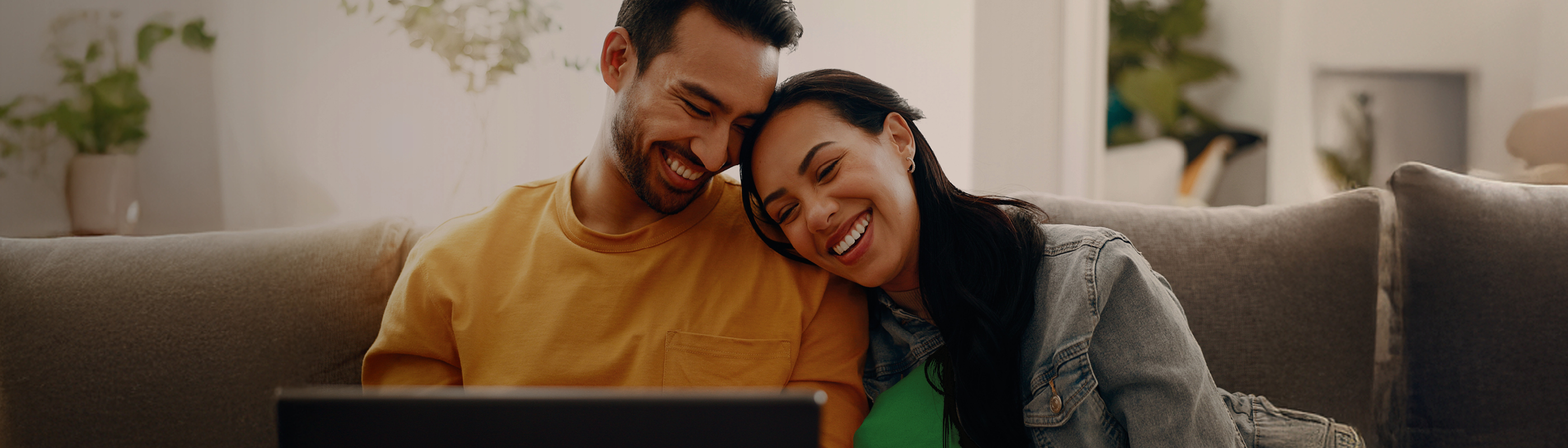 Couple souriant et regardant une tablette 