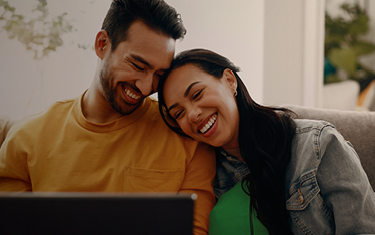 Glimlachend koppel dat naar een tablet kijkt