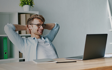 Glimlachende man die voor zijn computer zit